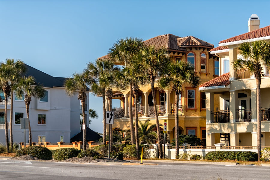 Colorful coastal homes and palm-lined streets in Miramar Beach highlight the area’s upscale vacation residences and relaxed beach community atmosphere.