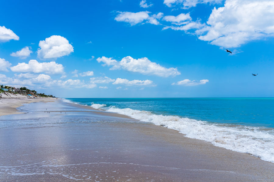 Beautiful shoreline at Wabasso Beach Park in Indian River County, Florida, where gentle Atlantic waves meet wide sandy shores under a bright blue sky.