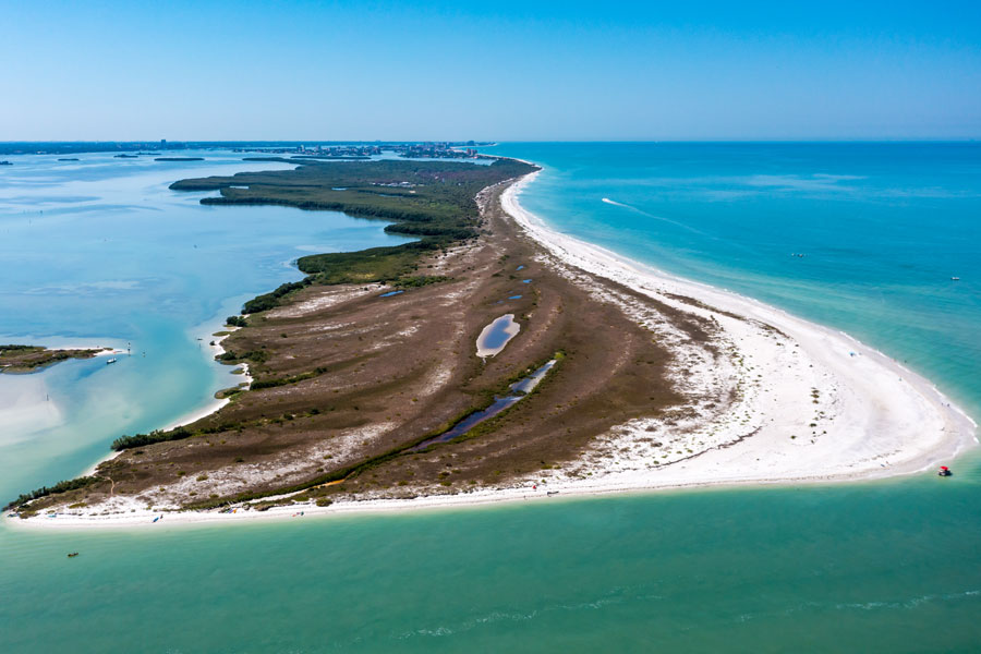 Aerial view of Caladesi Island State Park near Clearwater, Florida, showing undeveloped shoreline, white-sand beaches, and surrounding Gulf waters along one of the region’s most preserved coastal areas. File photo, licensed.