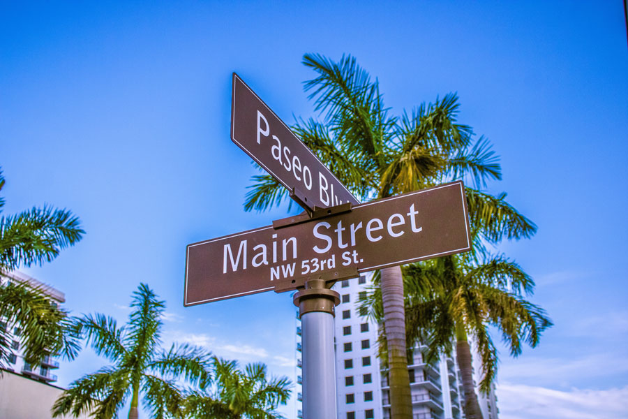 Street sign at Paseo Boulevard and Main Street in Downtown Doral, Florida, highlighting the walkable mixed-use district known for its shops, dining, and residential development.