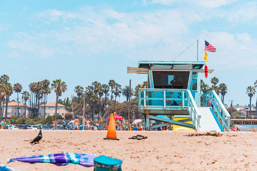 Lifeguard tower overlooking a busy Florida beach with safety flags in place, highlighting the importance of monitoring conditions before entering the water. Paying attention to warnings, surf, and local guidance helps swimmers make safer decisions at the beach.