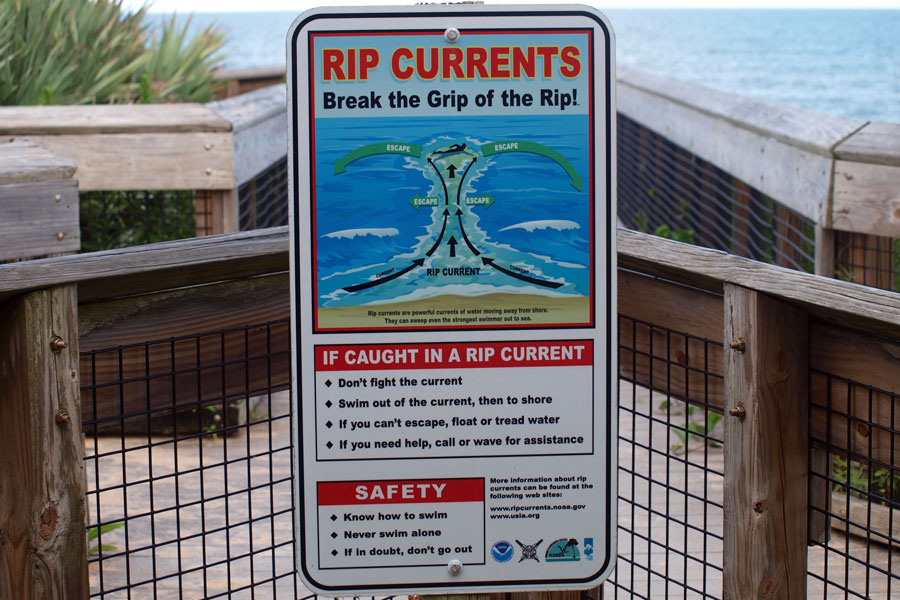 Rip current warning sign at a Florida beach access point, illustrating how these powerful currents form and how to escape them safely. Understanding posted signage and knowing what to do in a rip current can make a critical difference for swimmers.