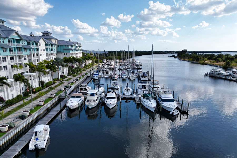 Aerial view of Little Harbor Marina in Ruskin, Florida, showing docked boats along a canal leading to Tampa Bay, with waterfront residences lining the shoreline. Photographed April 22, 2023.