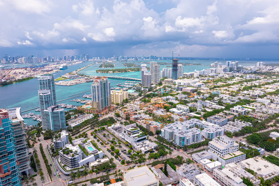 Aerial view of South Florida’s coastal skyline and waterfront neighborhoods, showing high-rise developments, marinas, and surrounding waterways that define the region’s urban and coastal landscape.
