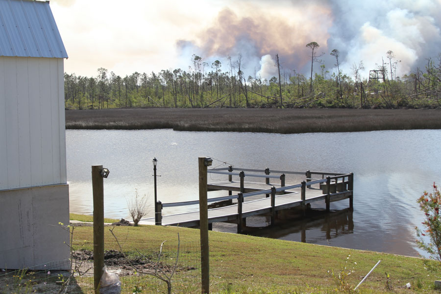 Smoke rises from the 2019 East Bay Fire across Cook's Bayou near Callaway after a wildfire, fueled by debris left behind by Hurricane Michael, burned more than 650 acres in Bay County. The fire highlighted the heightened wildfire risk that followed the hurricane as downed vegetation combined with dry, windy conditions throughout the region.