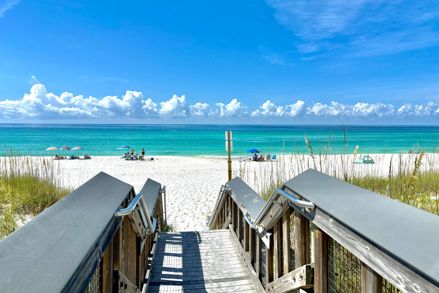 A wooden beach access walkway leads across the dunes to the brilliant white sand and emerald-green Gulf waters of Navarre Beach in Florida’s western Panhandle. Located on Santa Rosa Island, Navarre Beach is known for its wide shoreline, clear water and relaxed coastal setting between Pensacola Beach and the Destin-Fort Walton Beach area.