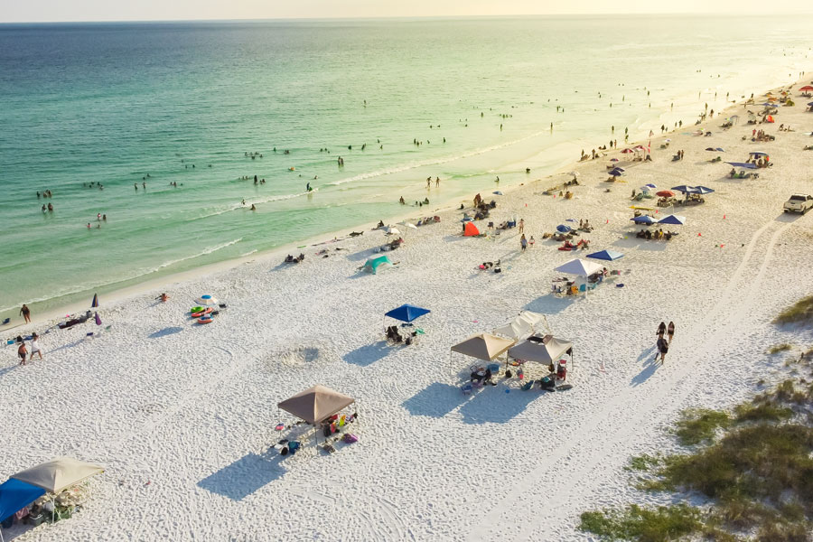 Aerial view of Miramar Beach along Florida’s Emerald Coast, where brilliant white sand meets the clear turquoise-green waters of the Gulf. Located in South Walton just east of Destin, the community is known for its expansive shoreline, swimming, watersports, beachfront accommodations and easy access to the attractions of both Destin and the 30A area.