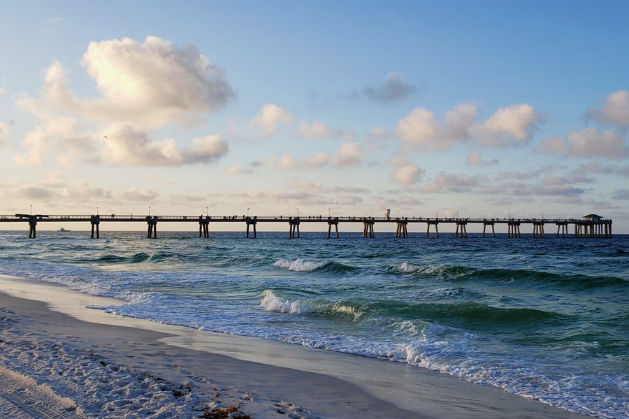 Okaloosa Island Pier extends into the Gulf of Mexico from the white-sand shoreline of Okaloosa Island near Fort Walton Beach. The long fishing pier offers expansive Gulf views and is a popular spot for fishing, sightseeing and watching marine life along Florida’s Panhandle coast.