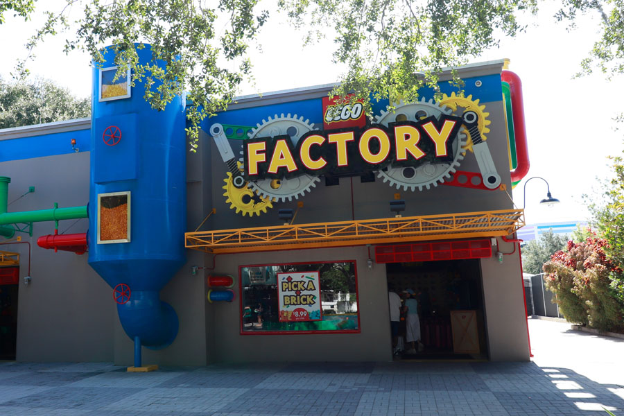The colorful LEGO Factory Experience and Store at LEGOLAND Florida Resort in Winter Haven features oversized gears, industrial-themed decorations and a playful entrance inspired by LEGO building bricks. Inside, visitors can explore how LEGO bricks are manufactured and browse the Pick A Brick wall, where guests can purchase individual bricks and pieces for their own creations. The attraction is part of LEGOLAND Florida, a family-oriented theme park in Central Florida. Photo credit: double2A, licensed.