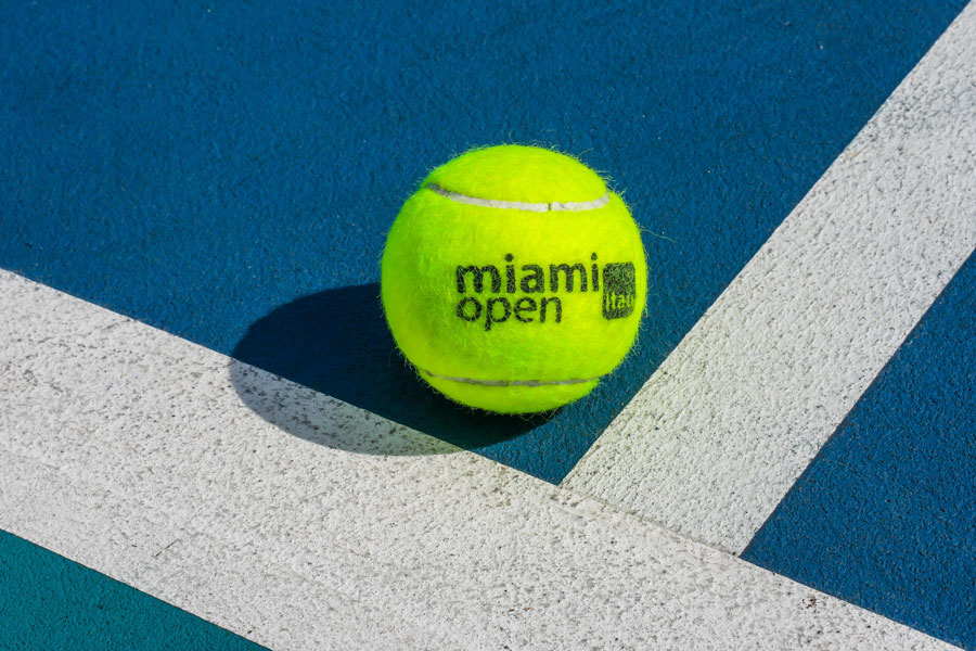 An official Miami Open tennis ball rests on the blue playing surface at Hard Rock Stadium in Miami Gardens, Florida, on March 31, 2023. The bright yellow Dunlop ball features the Miami Open tournament logo and represents one of South Florida's premier international sporting events. Held annually at the Hard Rock Stadium complex, the Miami Open attracts leading professional tennis players from around the world and features men's and women's competitions on specially constructed courts. Photo credit: Leonard Zhukovsky; licensed.