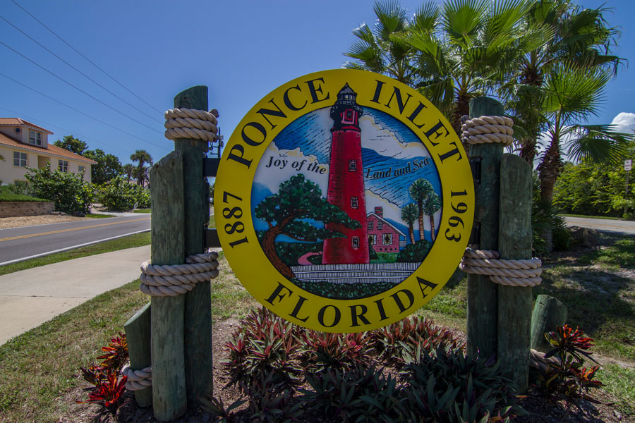Ponce Inlet’s distinctive town sign features an illustration of the historic Ponce de Leon Inlet Lighthouse, reflecting the community’s close connection to its maritime heritage. Incorporated in 1963, the small Volusia County town occupies the southern end of the barrier island between the Atlantic Ocean and Halifax River. The lighthouse depicted on the sign has served as one of the area’s defining landmarks since the late 19th century. Photo credit: Pelow Media; licensed.